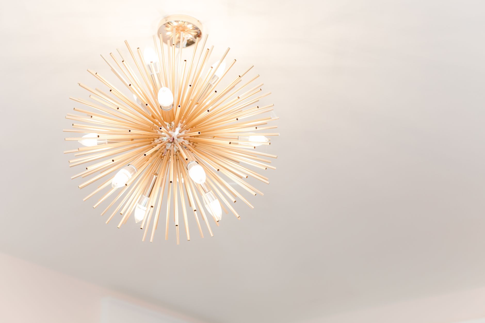 Capture d'un lustre moderne en forme d'étoile avec des ampoules lumineuses créant une déclaration artistique à l'intérieur.